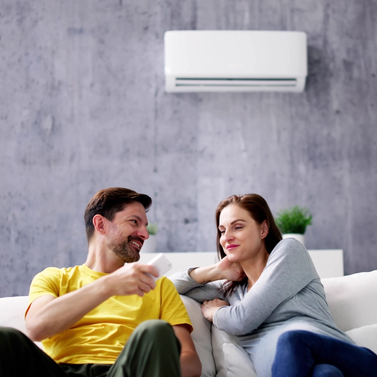 homem e mulher no sofá em baixo do ar condicionado